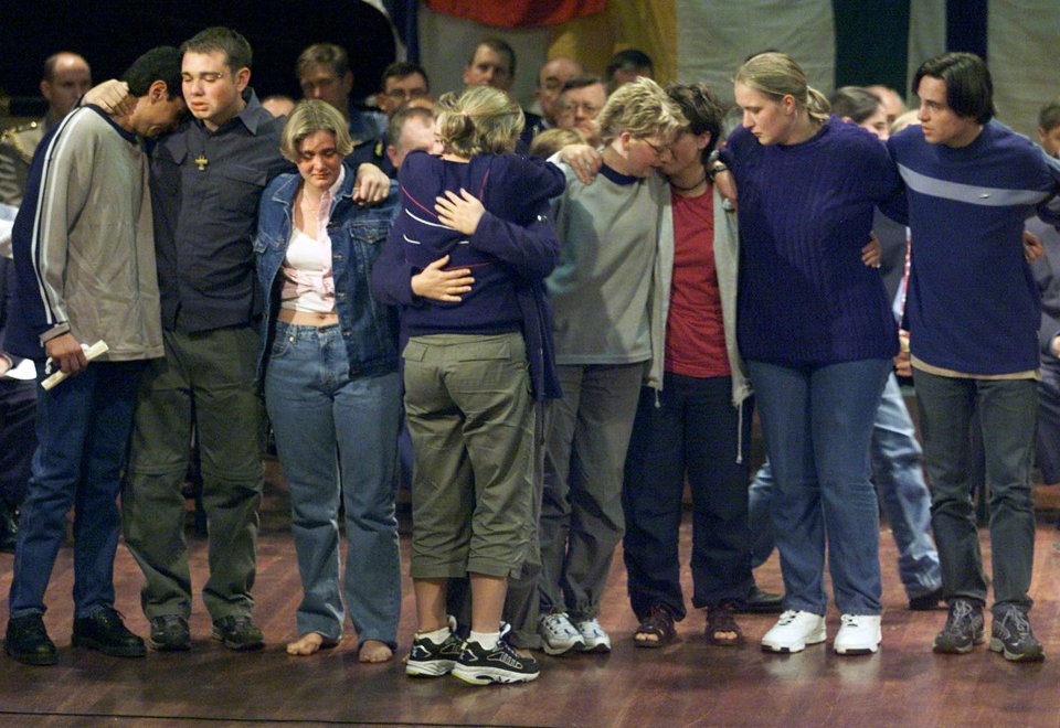  Survivors of the Palace Backpackers Hostel join each other on stage and embrace during a memorial service for the 15 victims of the fire in Childers