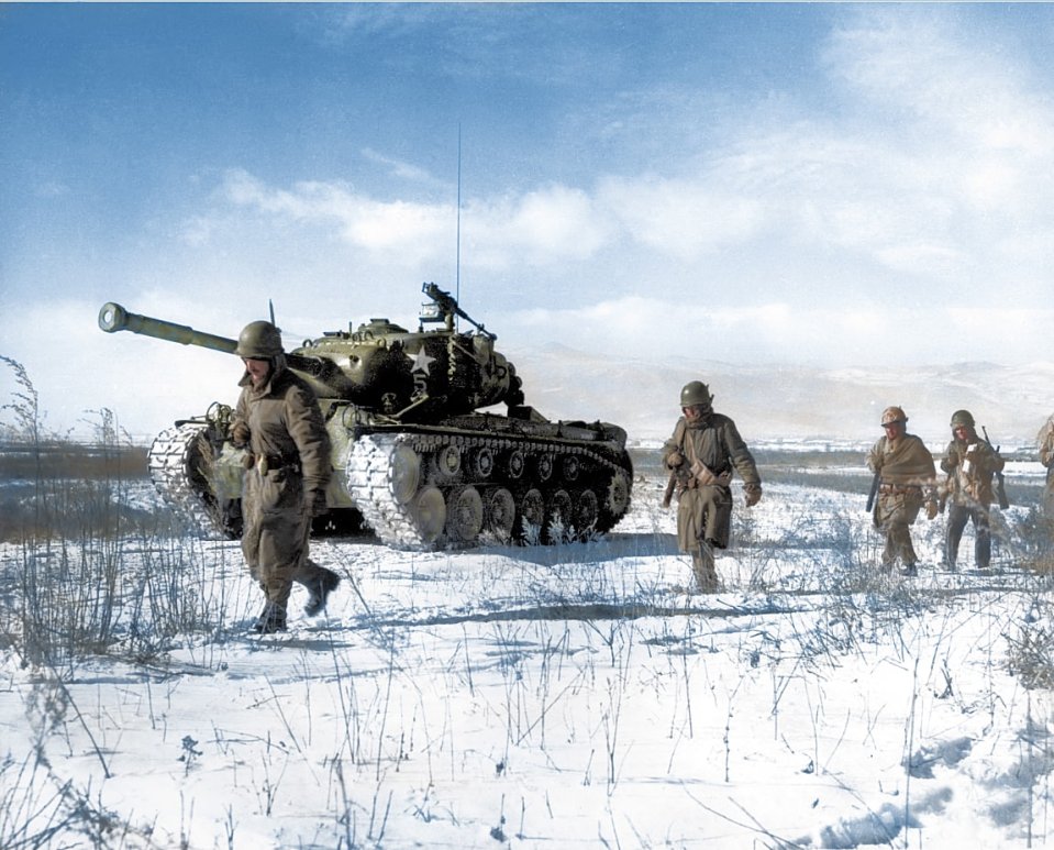 American troops tread through the snow during the Korean War