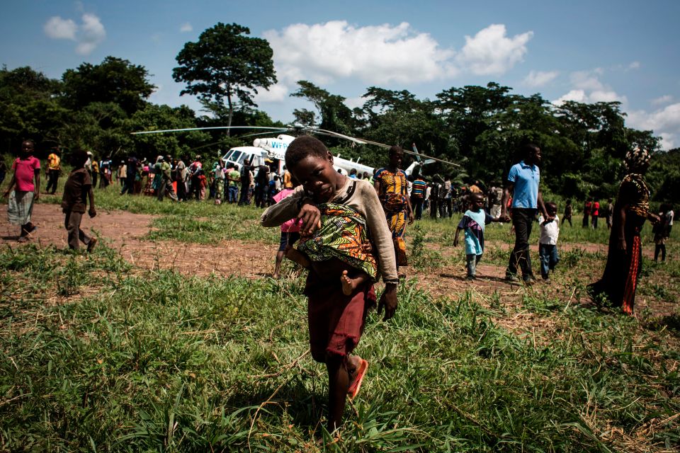  People gather as an helicopter carrying medical supplies and health workers arrives