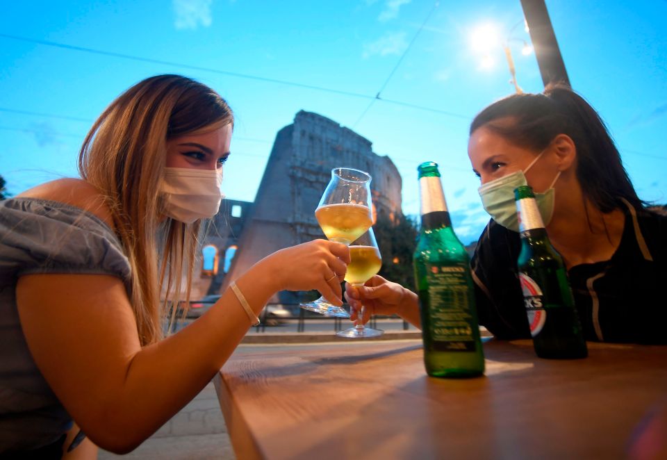 Two women have a drink outside in Italy where bar rules have been relaxed