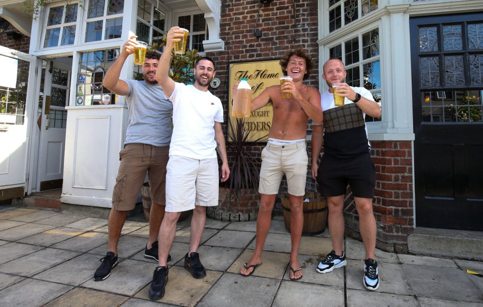 Punters with drinks outside The Sussex Arms Pub in Twickenham, West London 