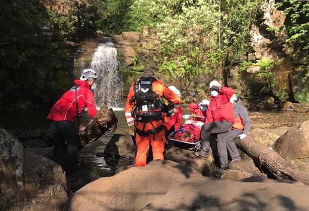 Rescuers wearing masks bring the man to safety