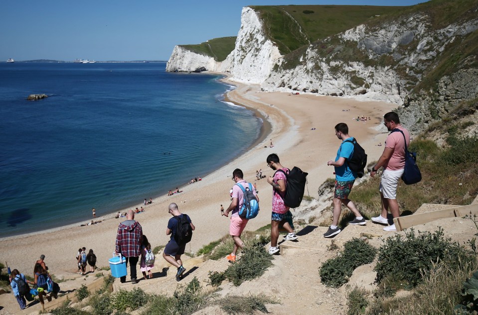 People make their way to the beach at Durdle Door on Monday