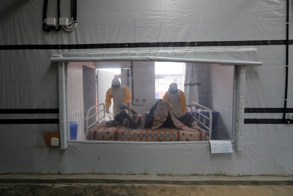  Health workers treat an Ebola patient