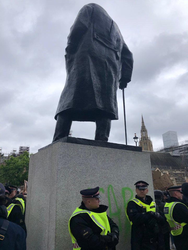  Police stand in front of the Winston Churchill statue after it was vandalised yesterday