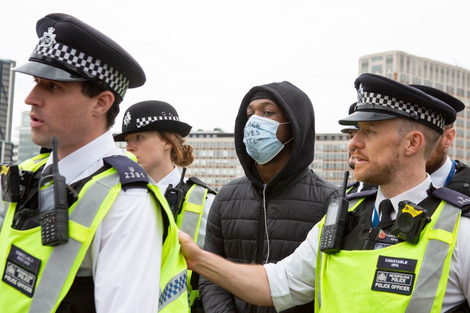  A protester is surrounded by police on Vauxhall Bridge