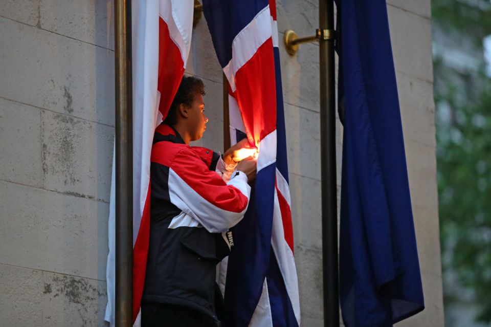  The protester uses a lighter and tries to set the flag on fire in Whitehall