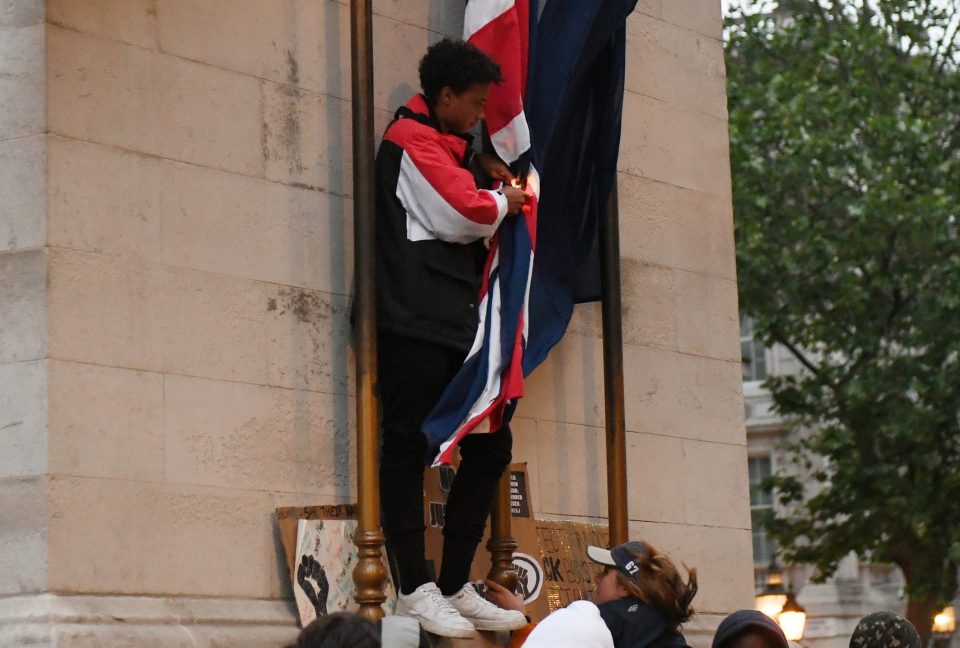  A young demonstrator sets a Union flag alight on the Cenotaph war memorial