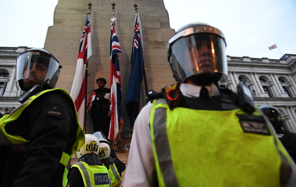  Riot police stand around the Cenotaph after a protester tried to burn the Union Flag