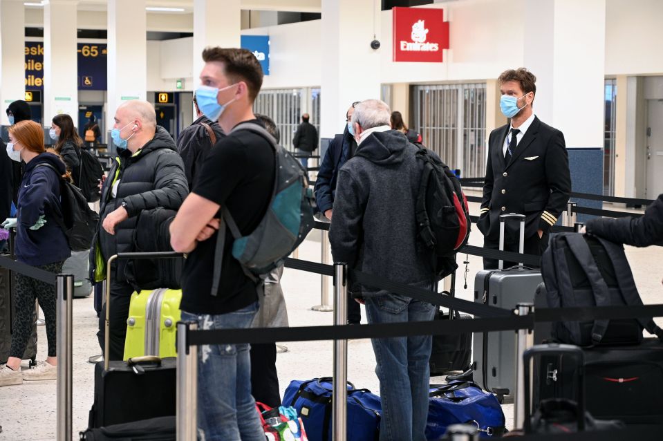  Passengers queue at Manchester Airport on Monday