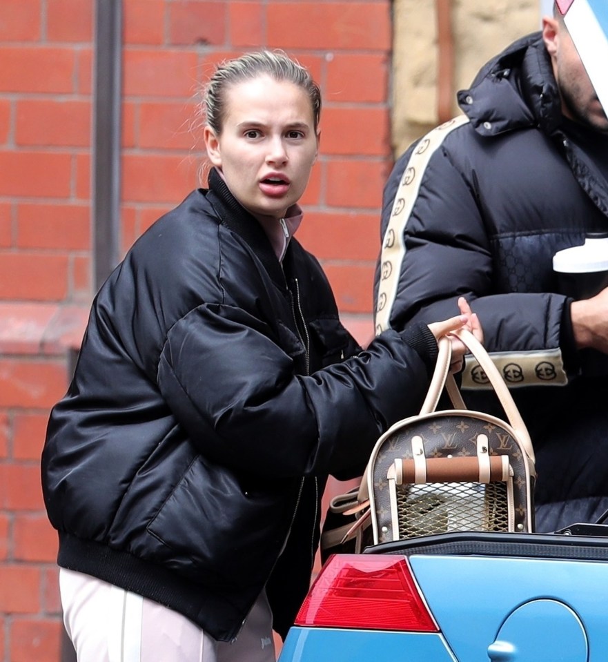  Molly-Mae loads an empty dog carrier into the back of her car