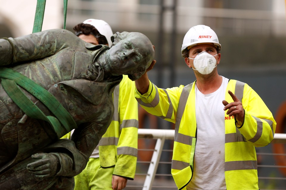 A statue of Robert Milligan is pictured being removed by workers outside the Museum of London Docklands near Canary Wharf