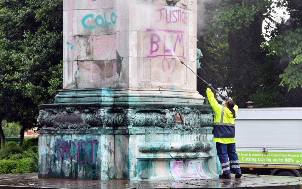 Council workers clean a statue of Britain's Queen Victoria that was defaced in Woodhouse Moor Park in Leeds