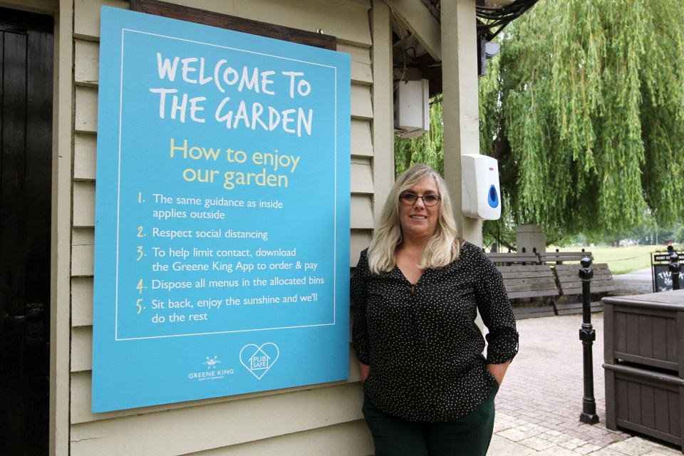 Sheree Thomas, general manager at the Green King Pub, Fort St George, stands next to the list of pub garden rules after the first lockdown