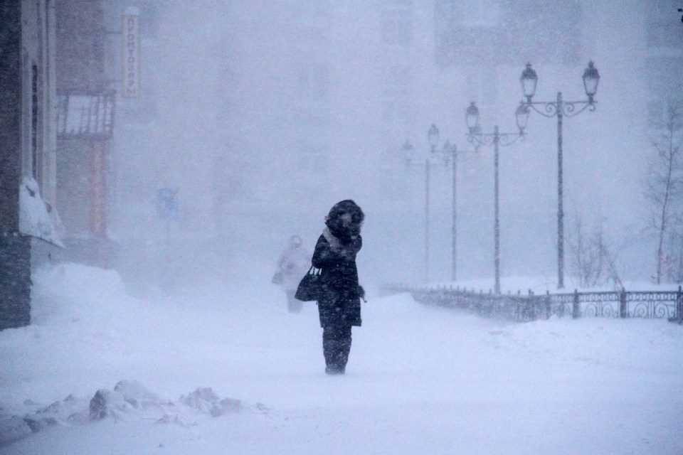  A woman walks outside in a snowstorm in Norilsk, Russia in February