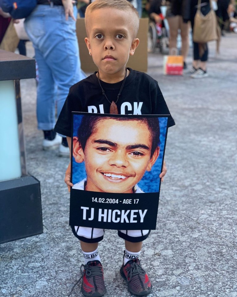 Quaden Bayles with a sign honouring TJ Hickey 