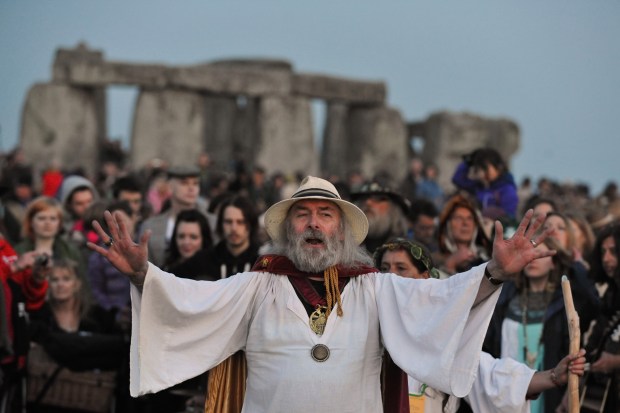 A druid conducts a ceremony before sunrise to mark the summer solstice at Stonehenge