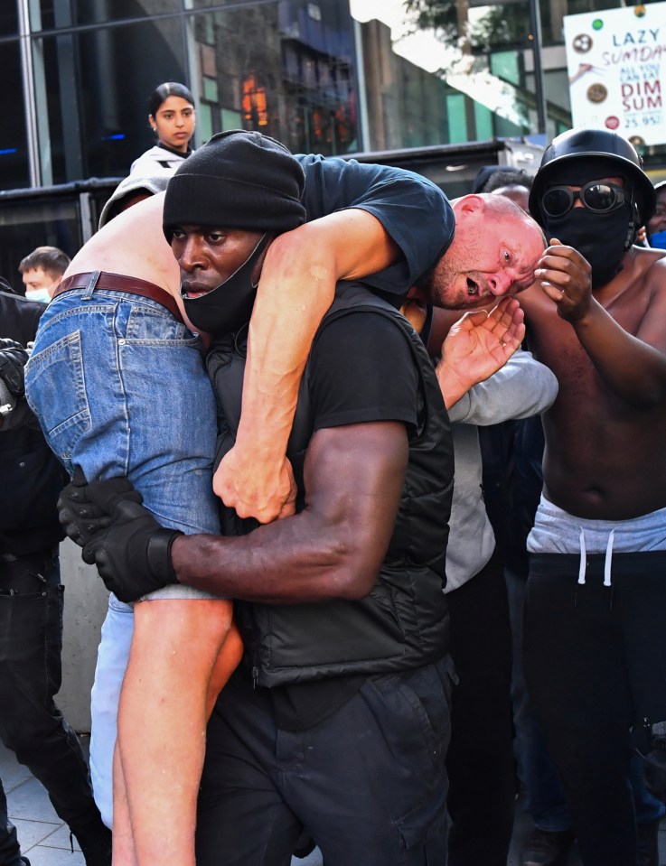 The stunned looking man was picked up over the rival protester's shoulder