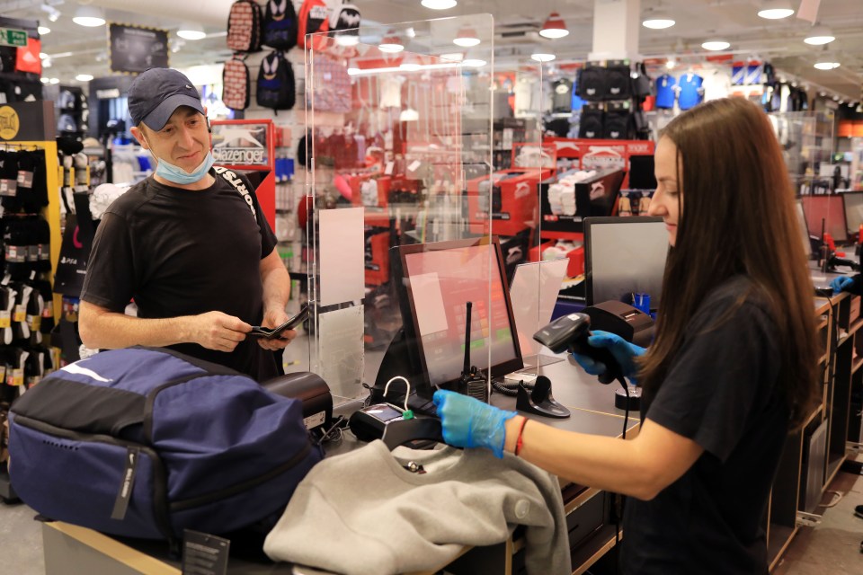  Customer Elliot Batt, 47,  is served behind a Perspex shield at Sports Direct