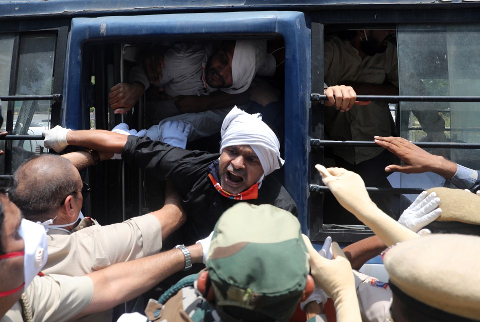 Indian police personnel detain Indian activists as they protest against China in New Delhi