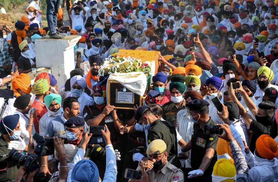 Family members and villagers carry the coffin of soldier Satnam Singh