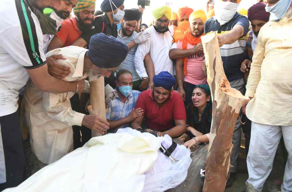 Family members cry over the body of soldier Satnam Singh