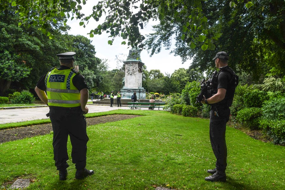 Police watch over a Queen Victoria monument which was defaced earlier this month in Woodhouse Moor park in Leeds