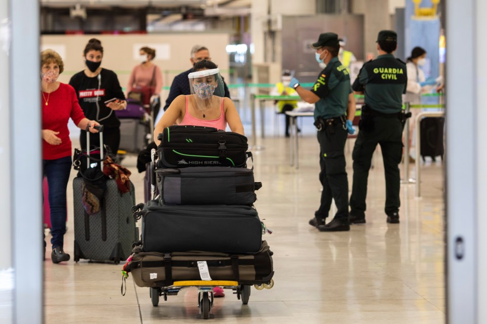 Passengers wearing face masks arrive at Adolfo Suarez-Barajas international airport, Madrid, Spain