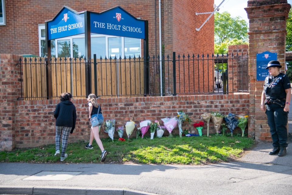 Mourning students leave floral tributes for their teacher