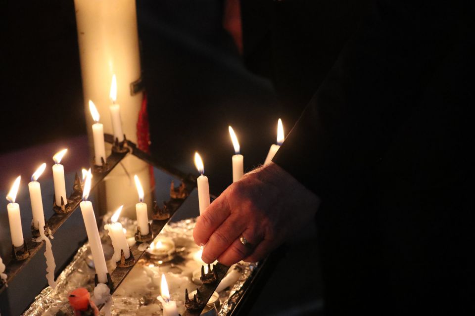 Candles are lit to pay tribute for the three people killed