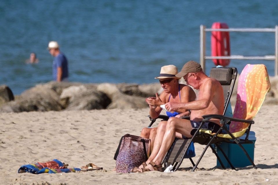 A couple ready for a sunny day at Branksome Beach in Poole