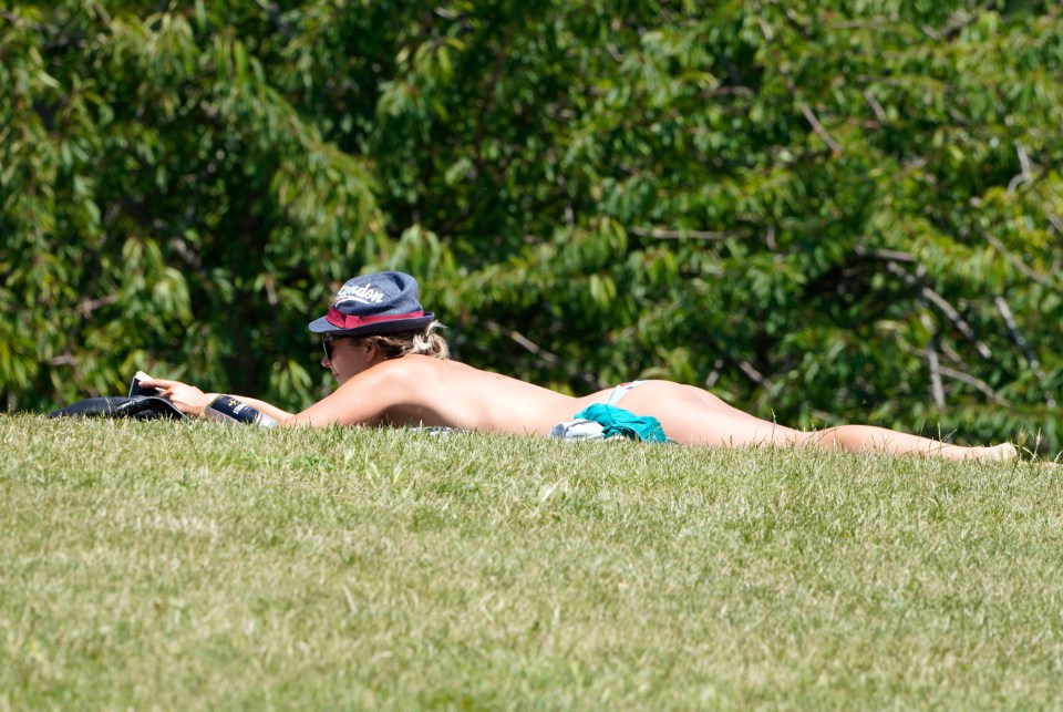 A topless sunbather relaxes at Battersea park