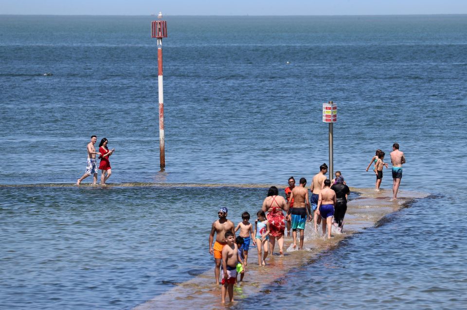 People walk around the edge of the sea pool in Margate, Kent