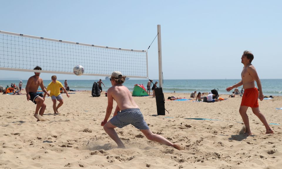 Sunbathers played volleyball on Boscombe beach in Dorset today