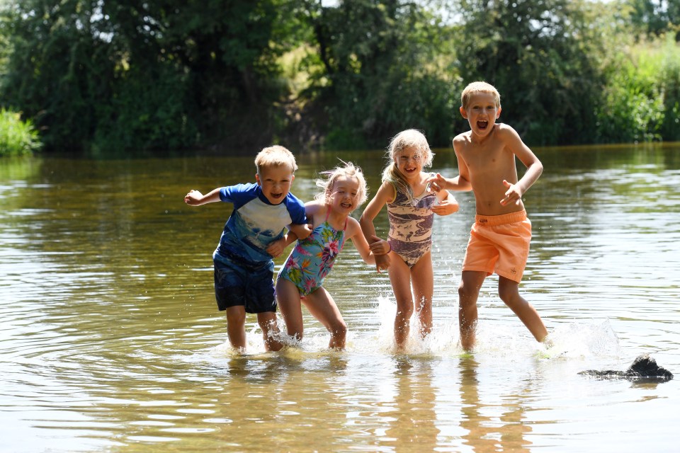 Kids enjoy the warm weather in the River Stour near Wimborne in Dorset