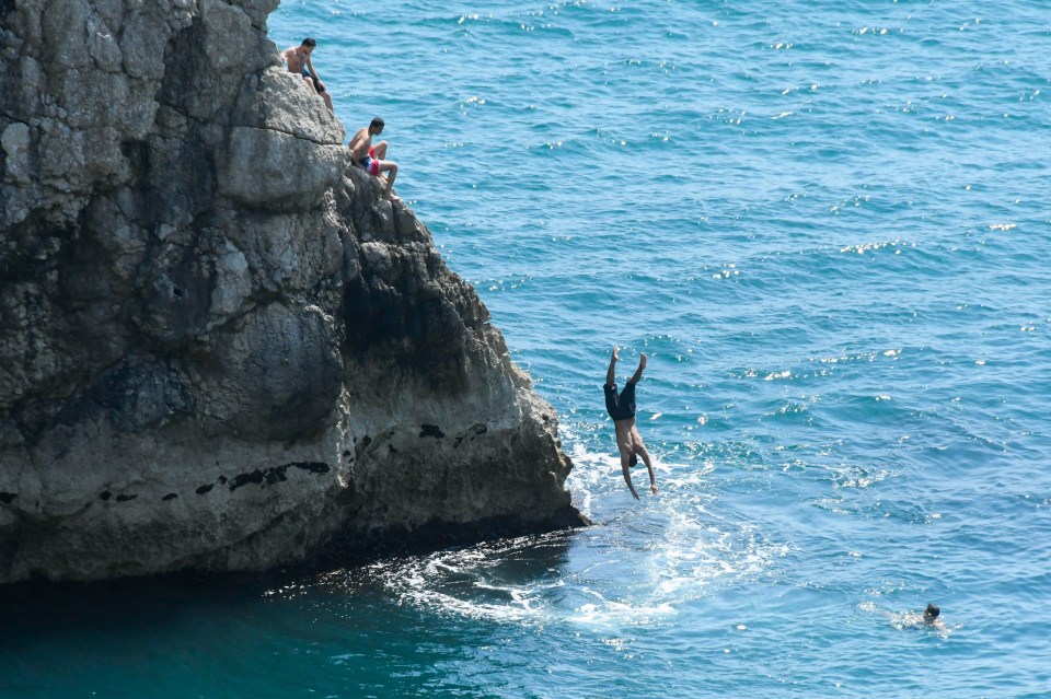 Daredevil bathers dived into the sea at  Durdle Door, Lulworth in Dorset