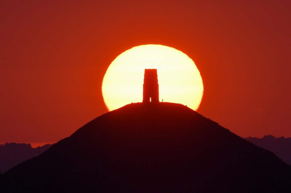 The sun rises over Saint Michael's Church on top of Glastonbury Tor, Somerset