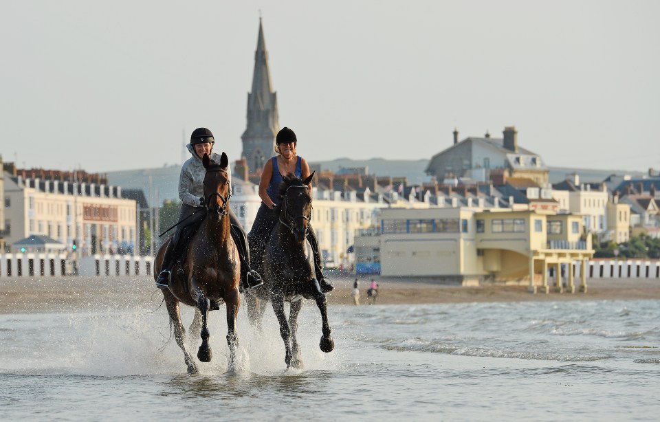  Horses gallop in front of the Georgian Terraces in Weymouth on Wednesday