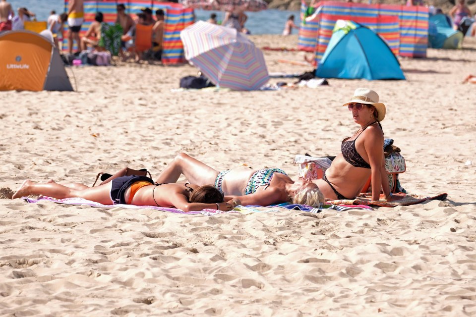  Sunbathers lay on the sand at Branksome beach