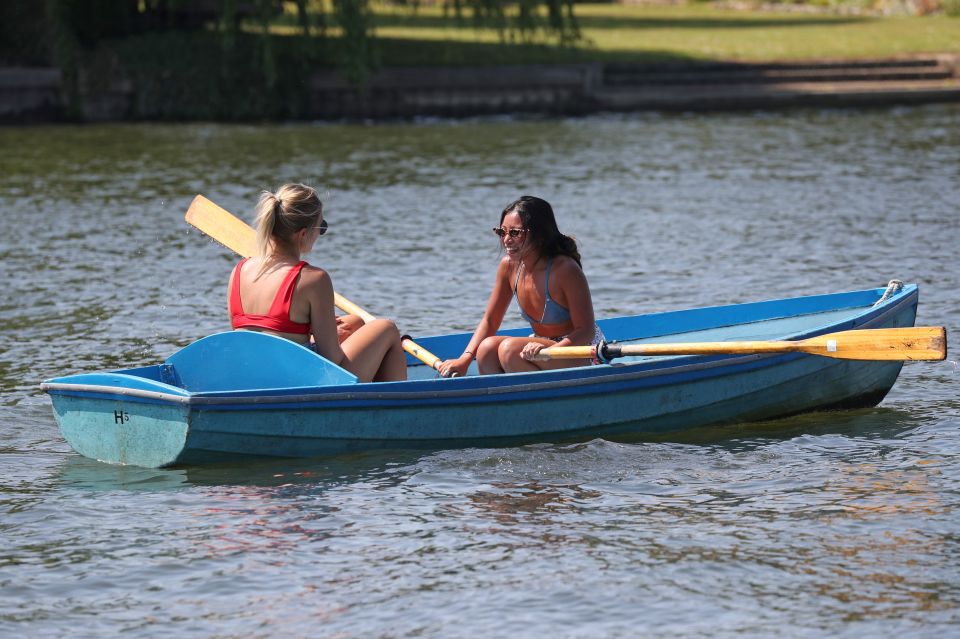  Friends enjoy the warm weather on a rowboat on the River Thames in Henley