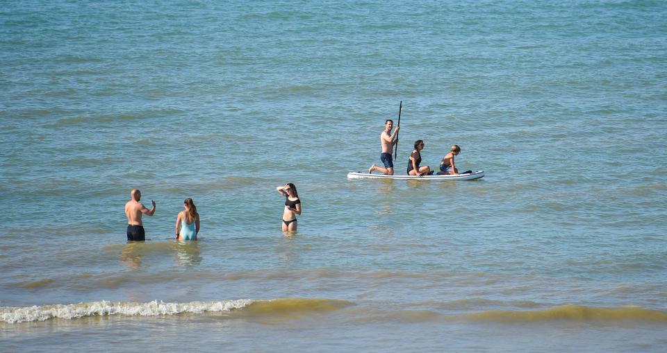 Swimmers head out for a morning dip in Brighton on Thursday