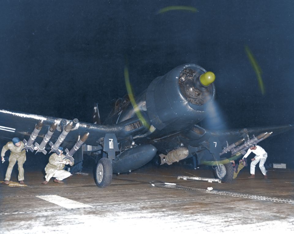 Marine Corps F4U-4B Corsair fighter-bomber receives final checks to its armament of bombs and five-inch rockets