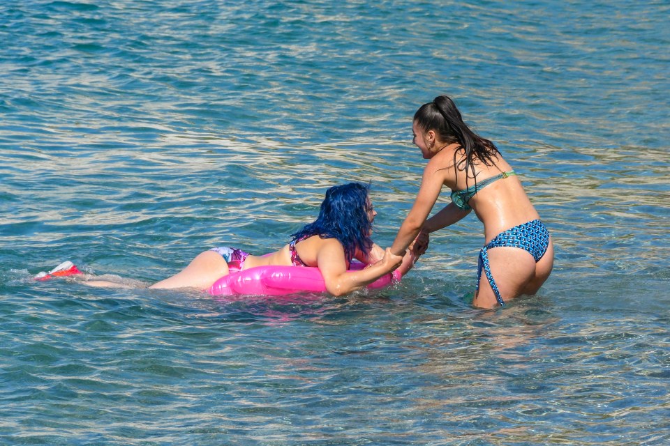 Pals frolic in the water at Durdle Door in Dorset on Thursday