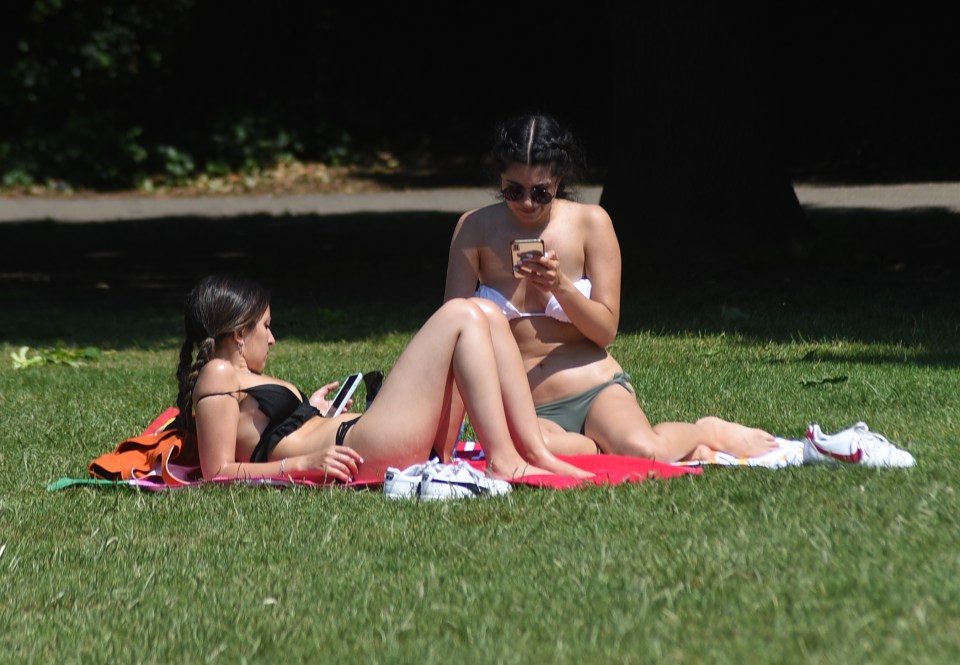 Sunbathers relax at Battersea Park in London