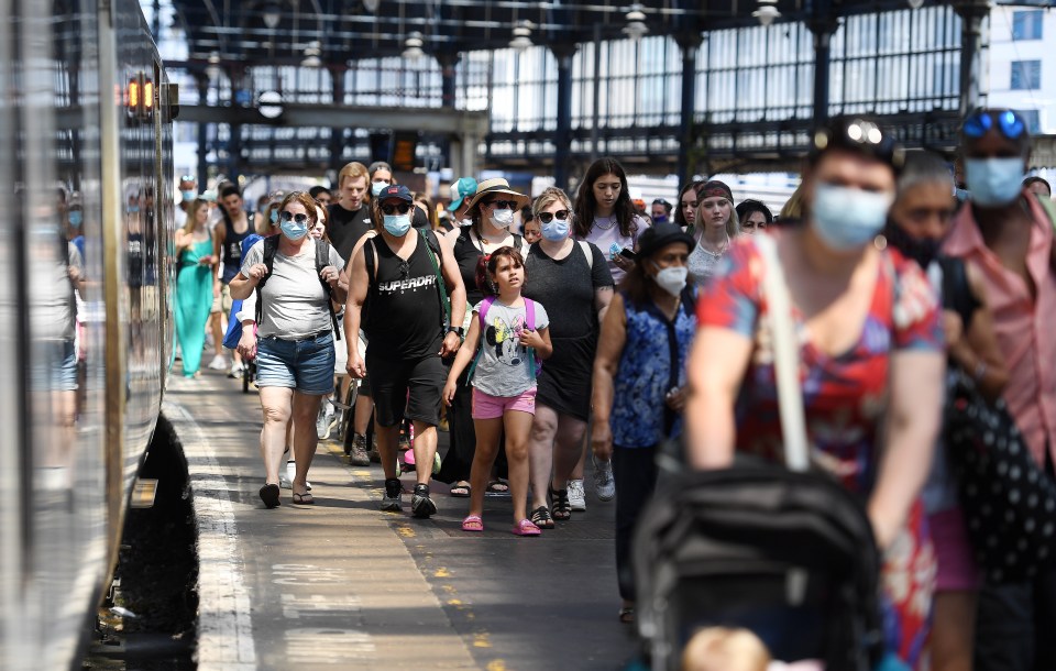 Passengers leave a packed train as they make their way to Brighton beach