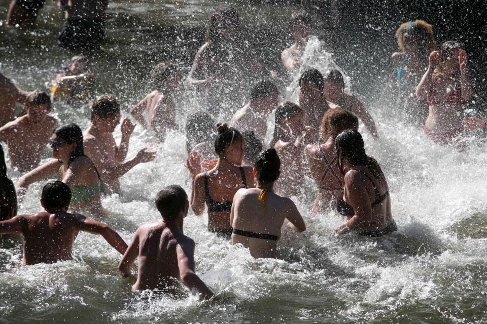 Crowds splash around in the Hackney Canal this afternoon