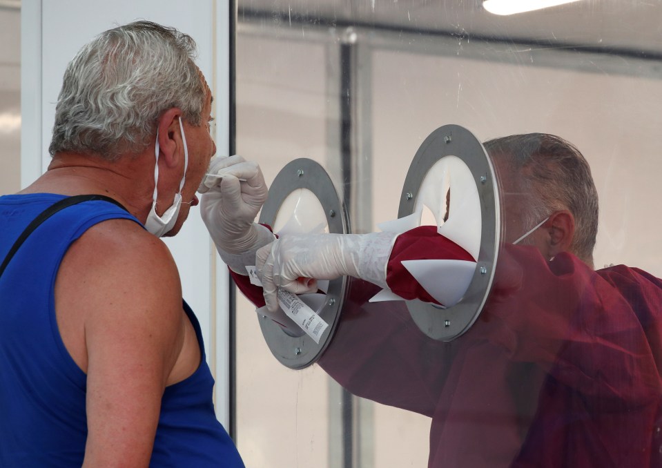 A resident is tested for coronavirus after 49 people tested positive in the village of Mondragone, northwest of Naples, Italy, June 26