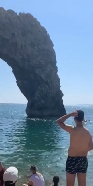 People on the beach watched as the men launched themselves off the cliffs