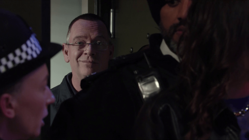  Ian was seen smiling - as he hid behind two police officers on EastEnders