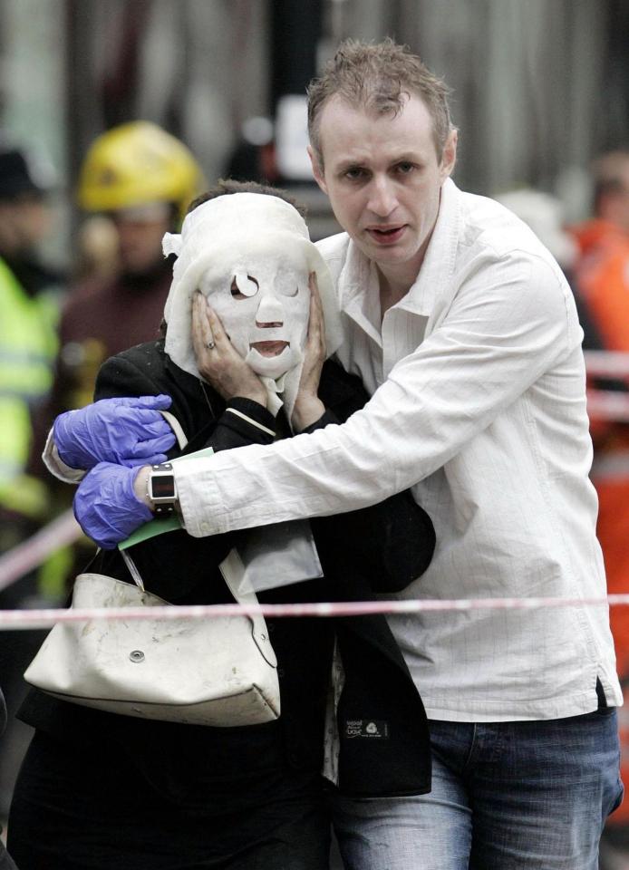  A survivor with a burnt face is led from the scene after a bomb at Edgware Road